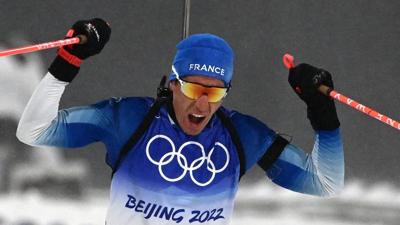 France's Quentin Fillon Maillet celebrates as he crosses the finish line to win the Biathlon Men's 12.5km Pursuit event