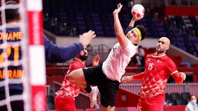 Handball player prepares to shoot ball at goal.