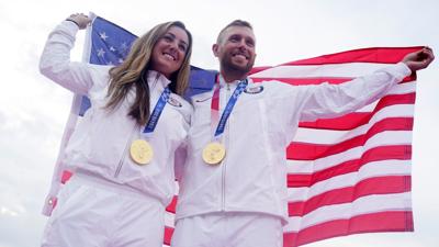 Olympic American shooters posing with gold medals and flag