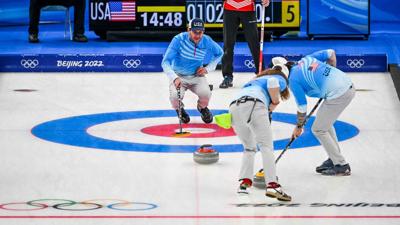 Curling athletes compete in an Olympic event.